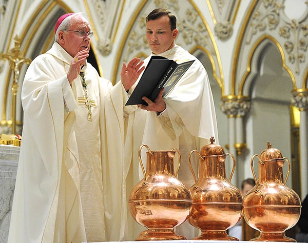 Bishop Richard Malone blesses vessel of olive oil at St. Joseph Cathedral during the annual Chrism Mass. (Dan Cappellazzo/Staff Photographer)